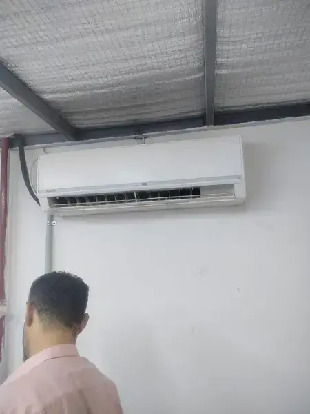 Wall-mounted Daikin AC with technician nearby